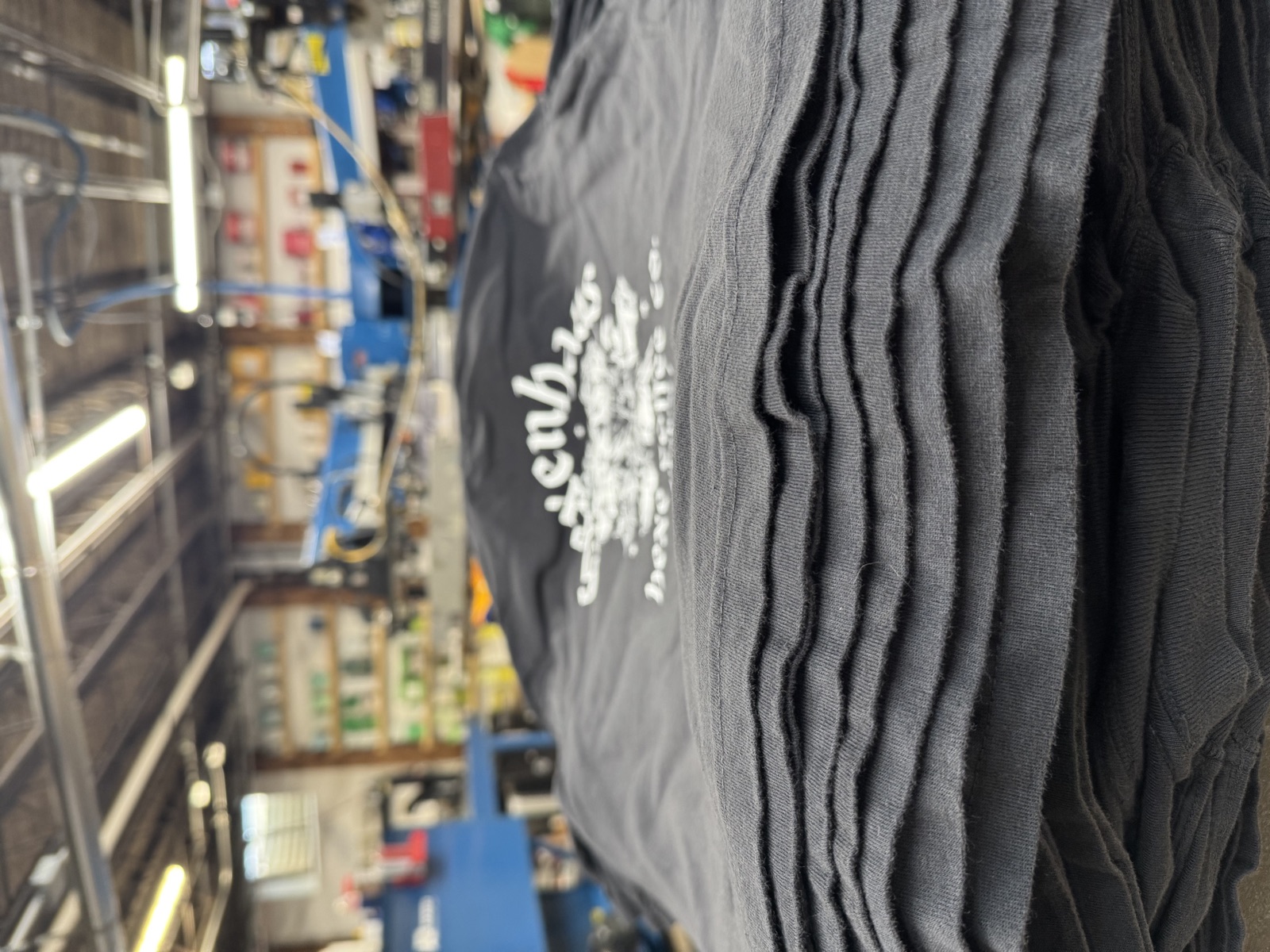 A black garment loaded on the press with registration lasers for a full-color DTF / Premium Film Print run at Sound & Fury