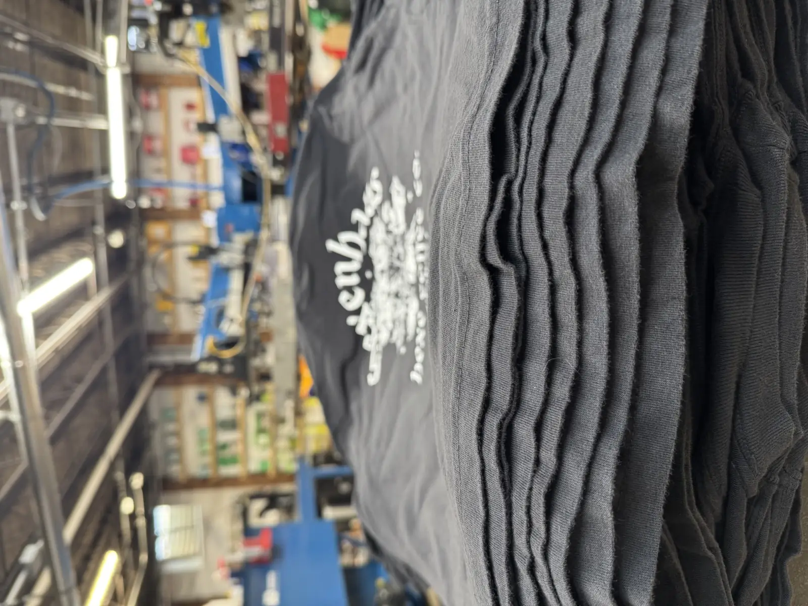 A black garment loaded on the press with registration lasers for a full-color DTF run at Sound & Fury in Warrenville, IL