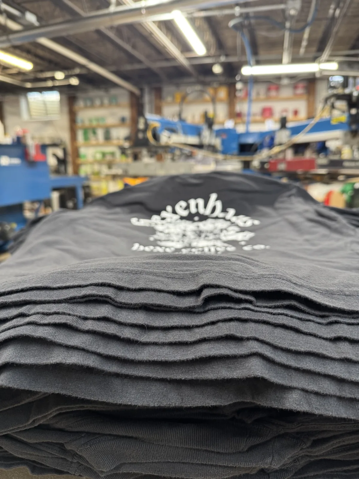 A black garment loaded on the press with registration lasers for a full-color DTF / Premium Film Print run at Sound & Fury